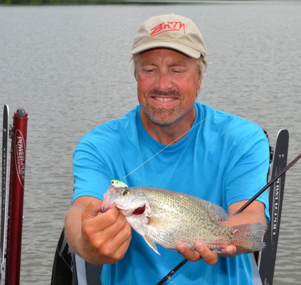 Garrett Steele, a professional crappie angler from Nashville, Tenn., admires a crappie he caught by vertically jigging a metal spoon while fishing in a backwater off the Alabama River near Prattville, Ala.