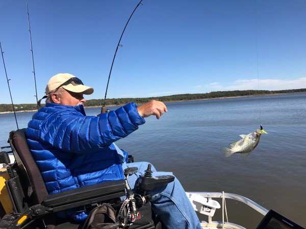 Swinging a crappie into the boat is part of the fun of any crappie trip. Here, Saldeen gets in on the fun.